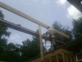 Carpenter setting a ridge beam over a new addition frame — Ice Dam Removal by Roofing Brothers in Crabtree