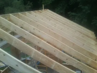New roof rafters set over an addition before sheathing in Crabtree
